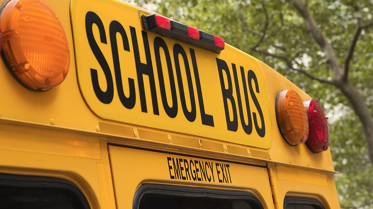 A close-up of automatic stop sign attached to school bus