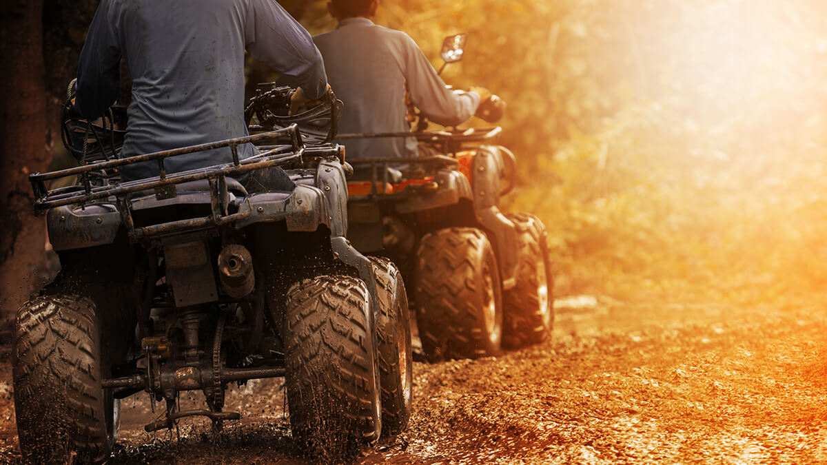 An ATV rider navigating over sandy dunes