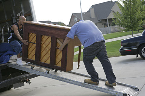 Two men moving piano on truck