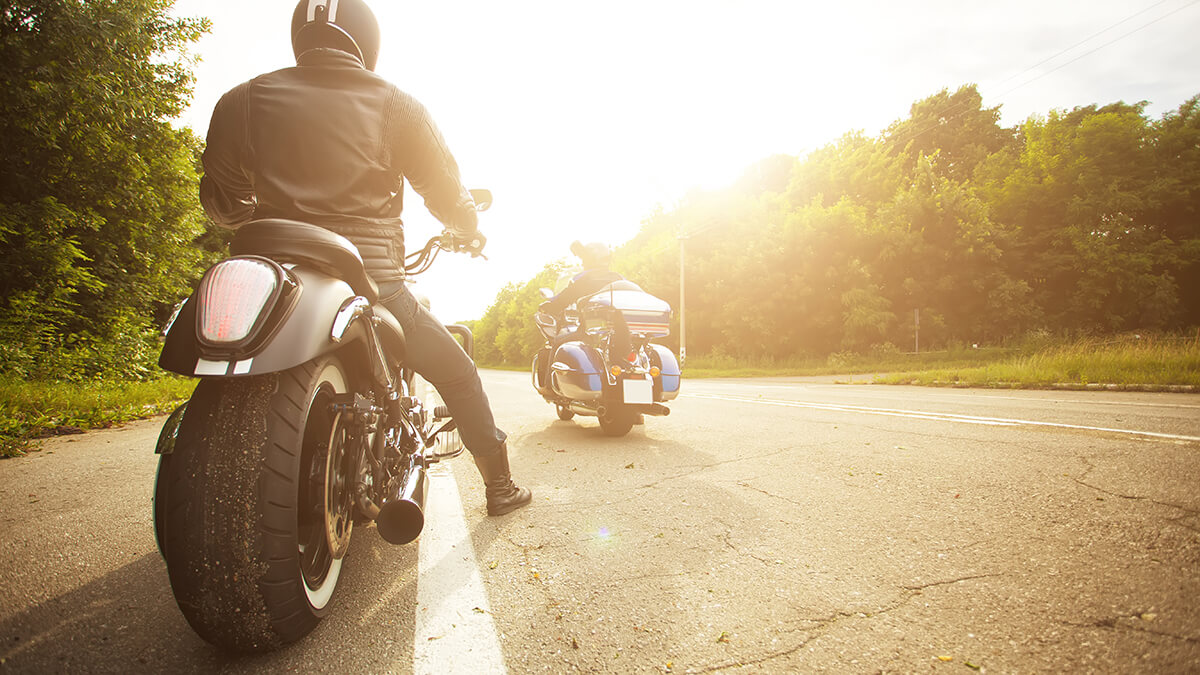 A close-up of a motorcyclist's boot while riding