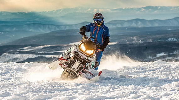 Several snowmobiles on a snowy trail