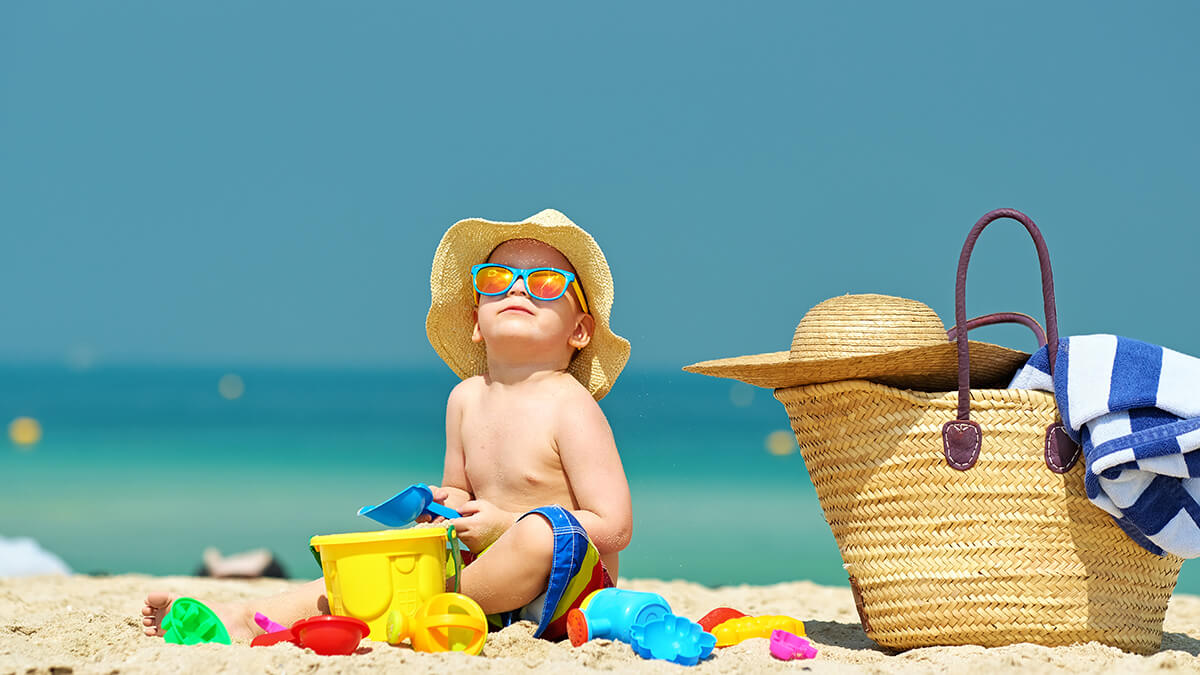 A water bottle near a towel and beach chair on the beach