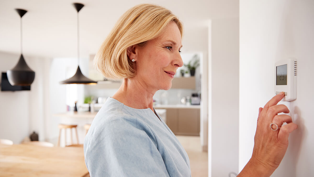 A close-up of a hand adjusting thermostat