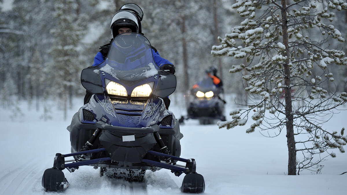 Snowmobiles sitting in the wintry midday sun