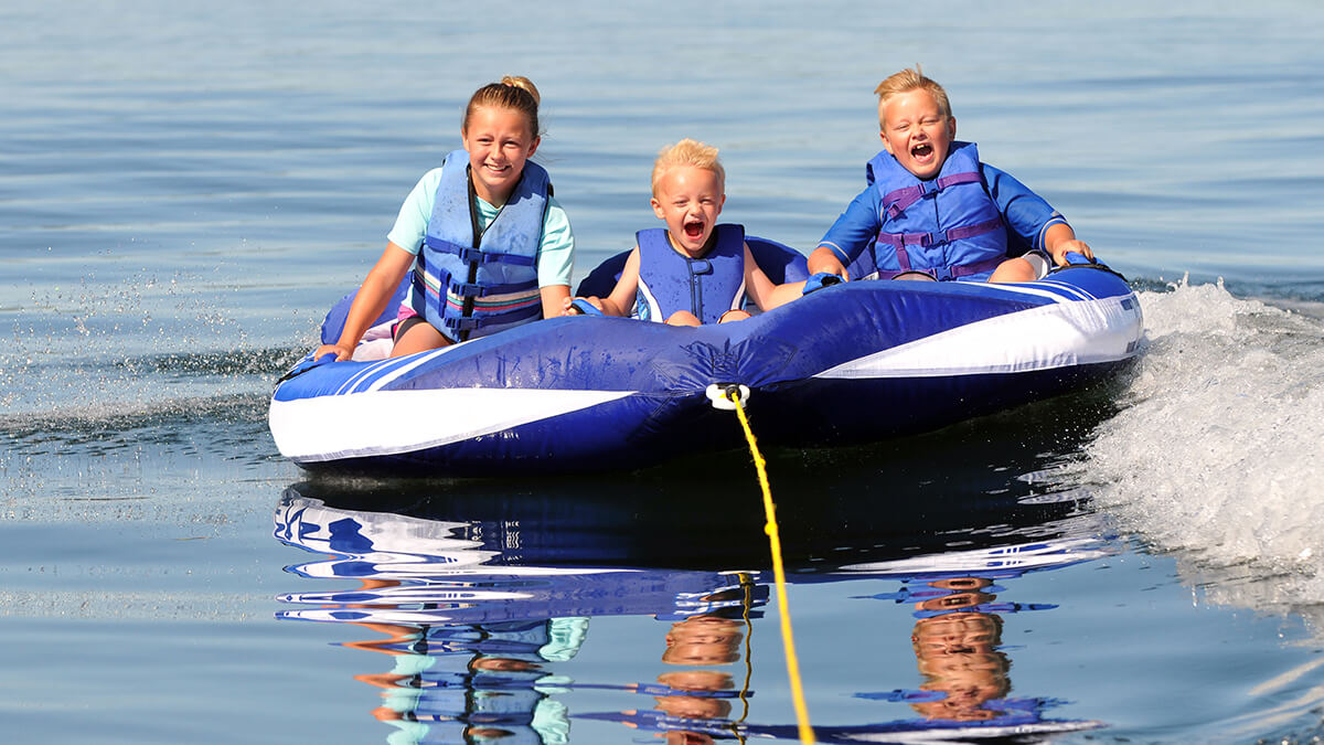 A family in a big tube being pulled by boat