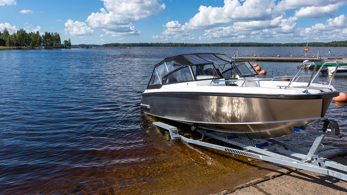 A pickup truck backing boat into lake from boat ramp