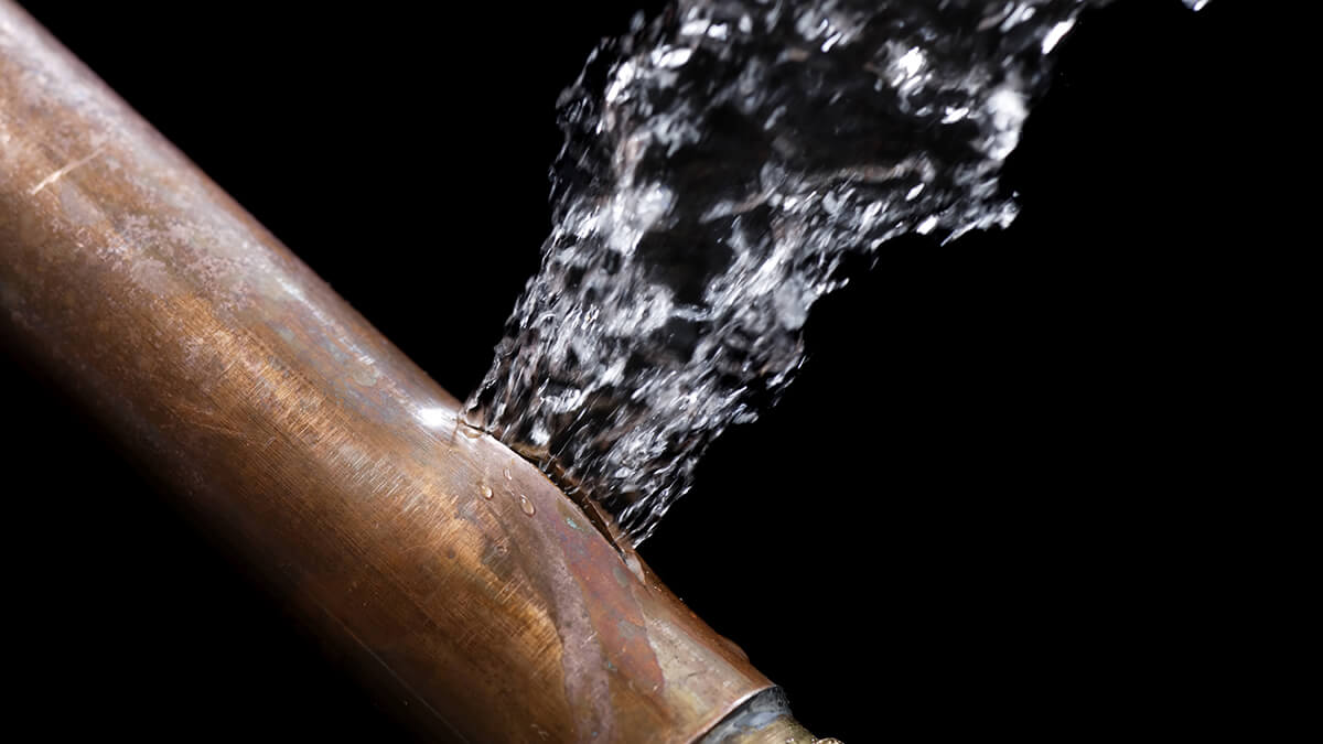 A close-up of a person working on copper pipes.