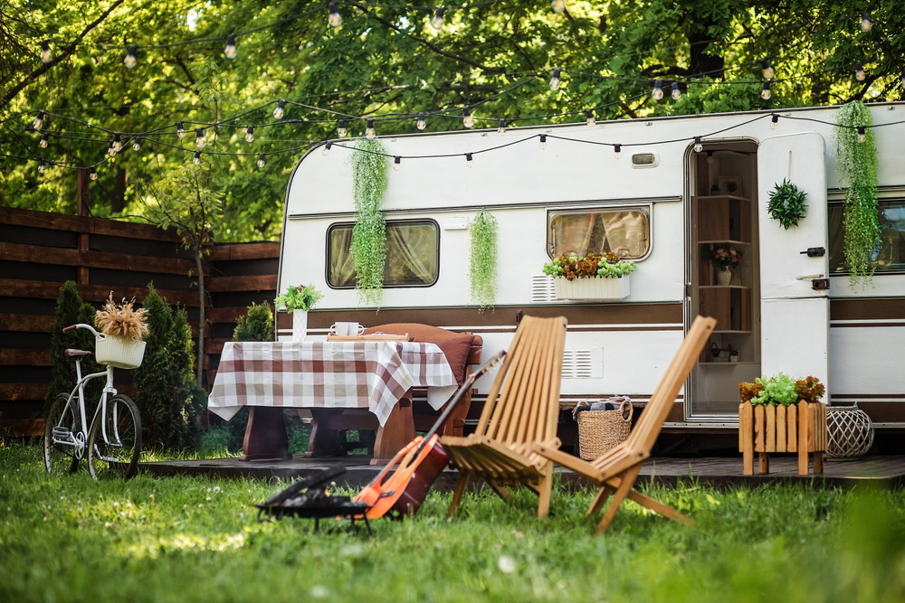 A travel trailer all set up with lights and outdoor table