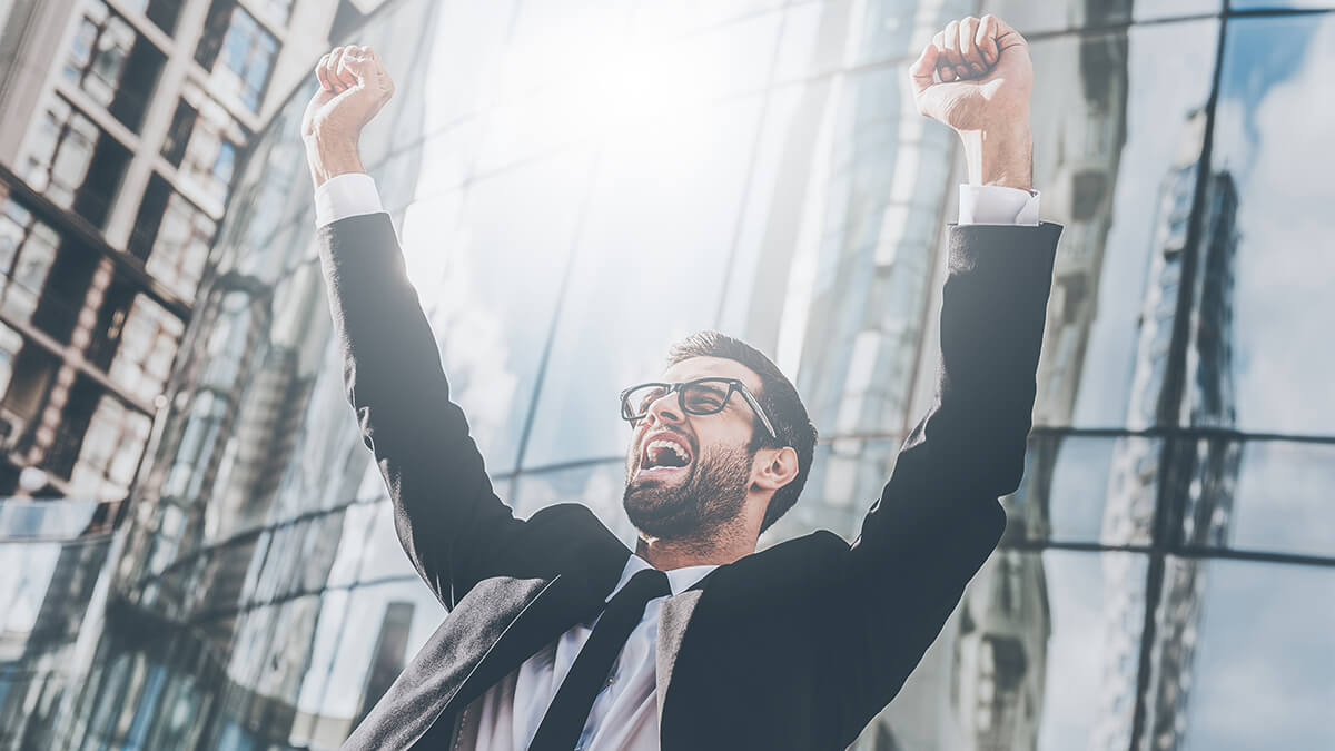 A joyful man with arms up and a look of victory on his face