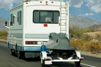 A motorhome pulling a personal watercraft trailer