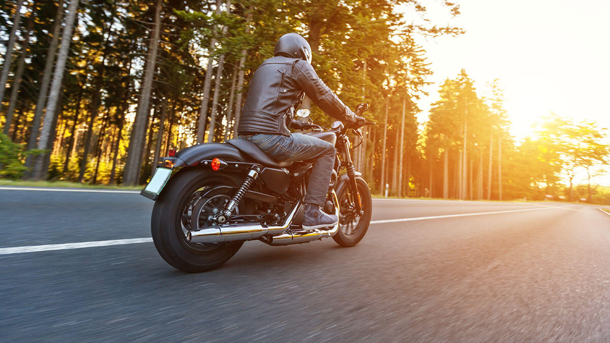 A motorcycle rider riding in the cool morning air