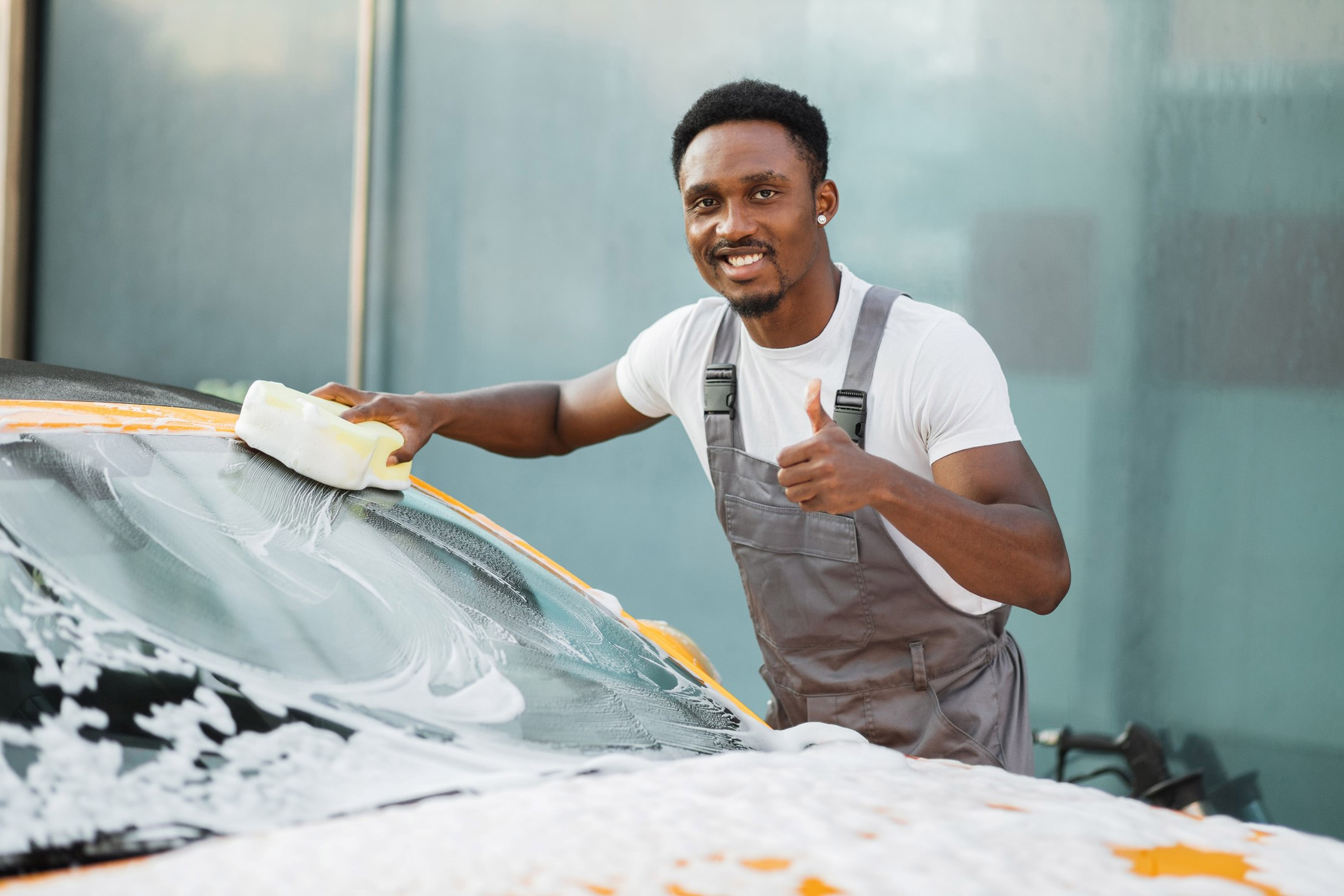 A young man washing his car